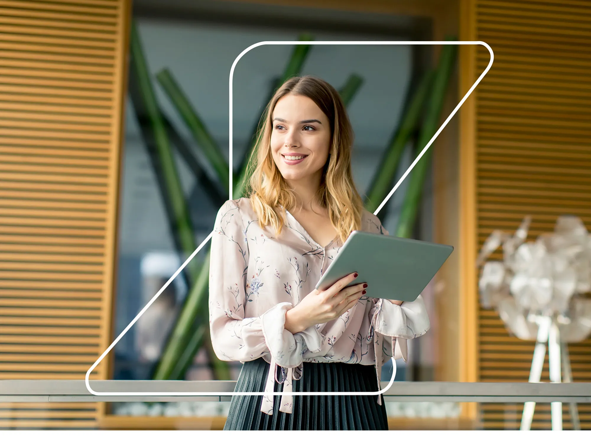 Smiling professional holding a tablet in a bright modern office